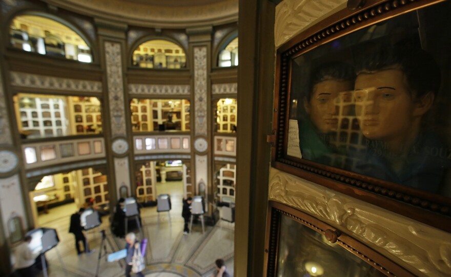 A pair of urns look out at people voting at the Neptune Society Columbarium in San Francisco on Tuesday. The columbarium was built in 1898 and is four stories tall, with thousands of niches for cremated remains.