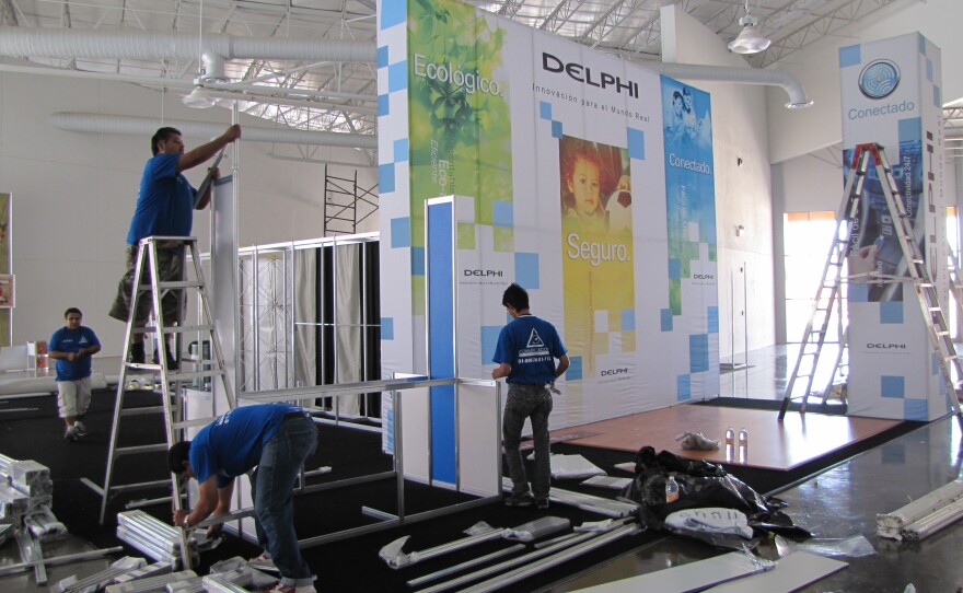 Workers set up exposition booths on the main floor of a children's museum that will host Juarez Competitiva.