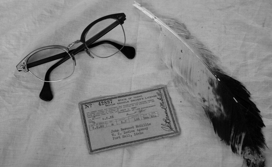 Items MacKnight's great grandfather collected in his trunk: an Idaho driver's license, horn-rimmed glasses, and an eagle feather.