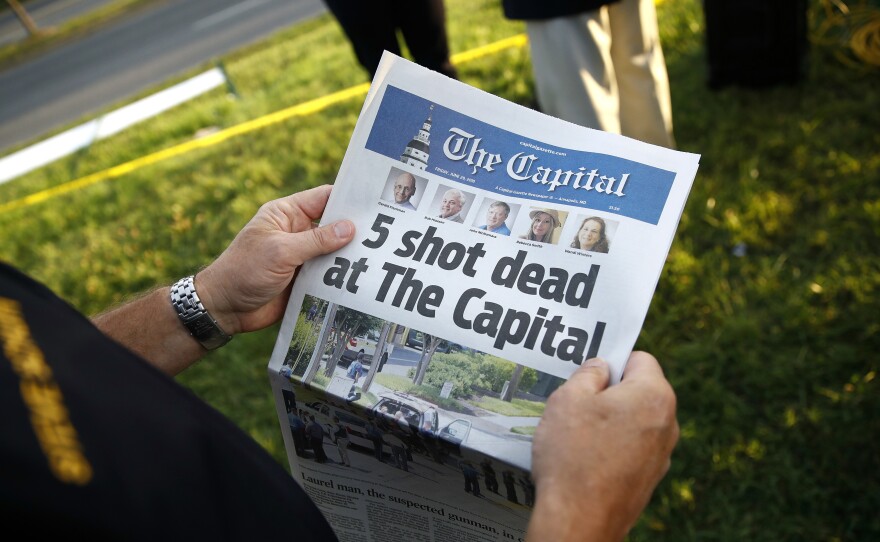 Steve Schuh, county executive of Anne Arundel County, holds a copy of The Capital newspaper last month near the scene of a shooting at the Capital Gazette newsroom in Annapolis, Md.