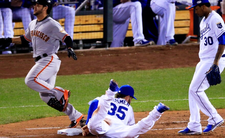 Tucked in the far side of each base is a microphone designed to pick up the scuffle of shoes and gloves. Here, the Royals' Eric Hosmer reaches first base just before the Giants' Gregor Blanco in Game 2 of the World Series.