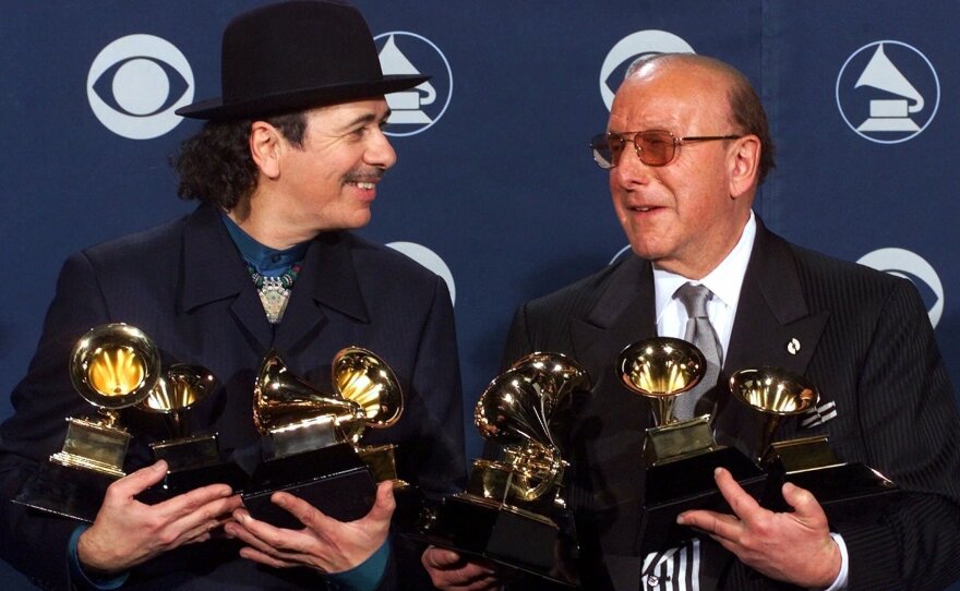 Davis and Carlos Santana pose with the musician's record-tying eight Grammys in Los Angeles in 2000.