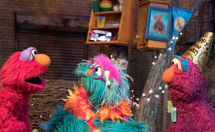 It’s New Year’s Eve on Sesame Street! Rosita (center) and Telly (right) try to help Elmo (left) stay awake until midnight so he can celebrate with his friends.