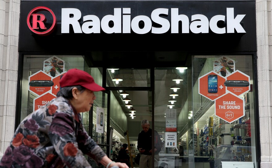 A person rides by a RadioShack store in San Francisco, Calif.
