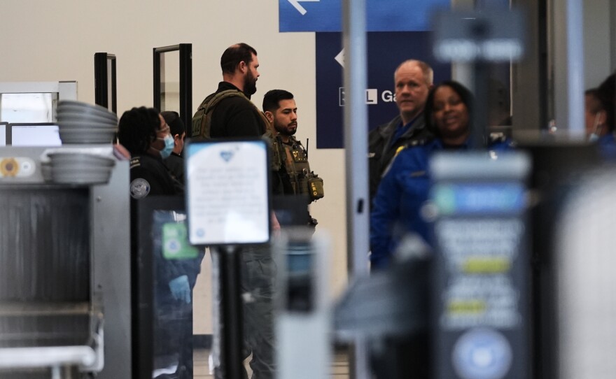 Immigration and Customs Enforcement  agents work at the baggage check and security control x-ray area at O'Hare International Airport in Chicago on Tuesday.