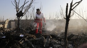 A rescue worker searches the scene where an Ukrainian plane crashed in Shahedshahr, southwest of the capital Tehran, Iran, Wednesday, Jan. 8, 2020.