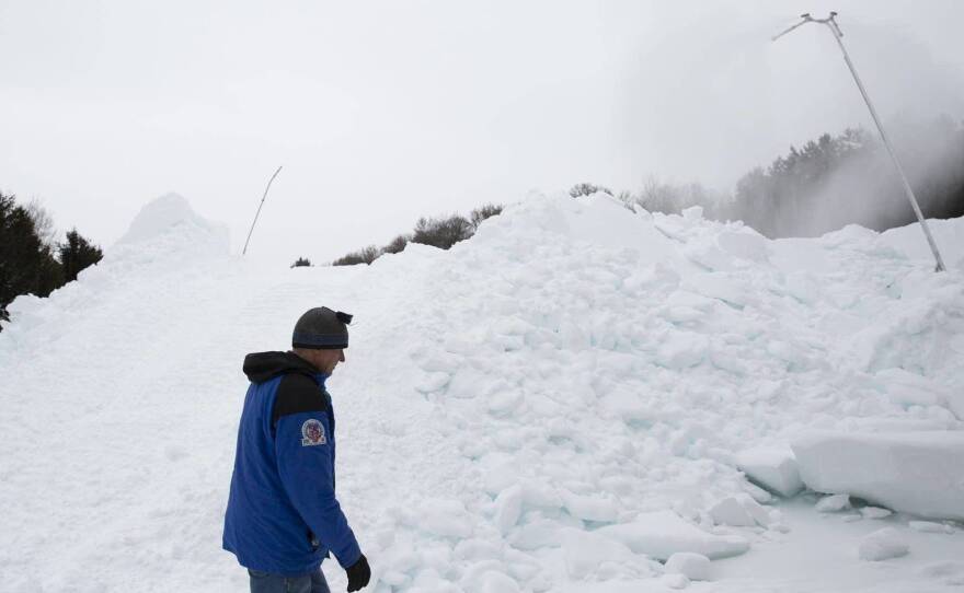 Volunteer Don Olson walks past a mound of artificial snow created by a snow gun on Tuesday at the Vasaloppet Nordic Ski Center in Mora, Minn.