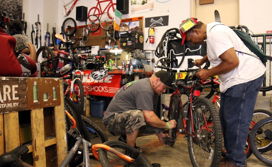 Jason Orth, manager of the Reading Bike Hub, fixes a bike for a customer.