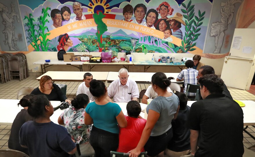 Ruben Garcia (center), director of the Annunciation House, speaks with migrant parents on June 26, 2018, in El Paso, Texas.