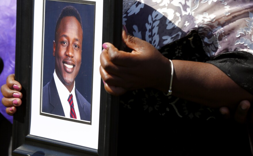 Ouko holds a portrait of her son outside the Dinwiddie Courthouse in Dinwiddie, Va., on March 16.