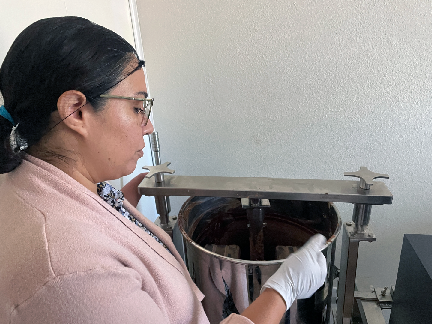 Elizabeth "Ely" Rosales Aguilar grinds cacao.