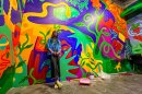 Artist Mithsuca Berry is shown with their Octavia Butler-inspired mural in an undated photo at the New Children's Museum in San Diego, Calif. The mural is part of an interactive exhibit inspired by the work of Butler, who was an influential science fiction writer.