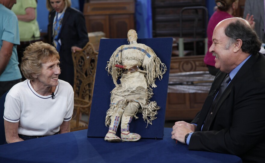 Bruce Shackelford (right) appraises a Plains Indian doll, ca, 1880, in Madison, Wis. ANTIQUES ROADSHOW “Vintage Madison 2024, Hour 2” premieres Monday, October 28 at 8/7C PM on PBS.