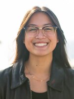 photo of Elaine Alfaro, female wearing glasses, black jacket and smiling at the camera