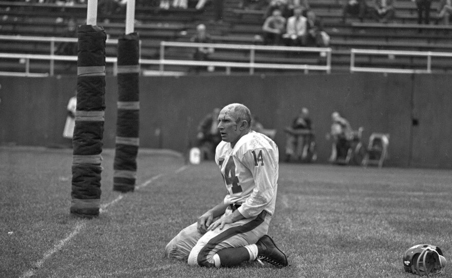 In this iconic photo from Sept. 20, 1964, New York Giants' Y.A. Tittle squats on the field after being hit hard while passing during a game against the Pittsburgh Steelers.