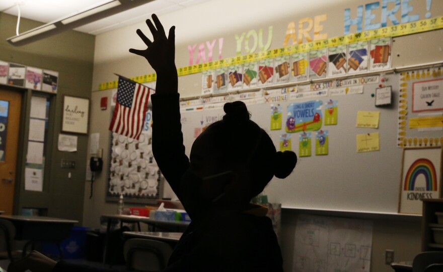 A first grade student raises her hand at Mary L. Fonseca Elementary School in Fall River, Mass., in November.