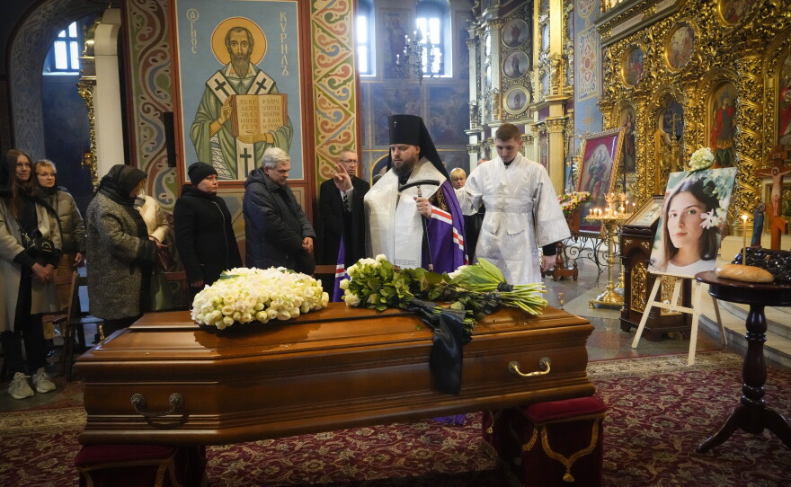 A priest prays over Kuvshynova's coffin during a funeral service at St. Michael's Cathedral in Kyiv on March 20, 2022.