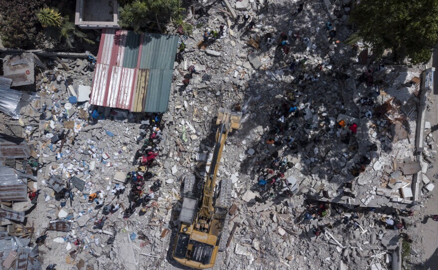 <strong data-stringify-type="bold">Mon., Aug. 16: </strong>A bulldozer works at the site of the collapsed Hotel Le Manguier in Les Cayes, Haiti.