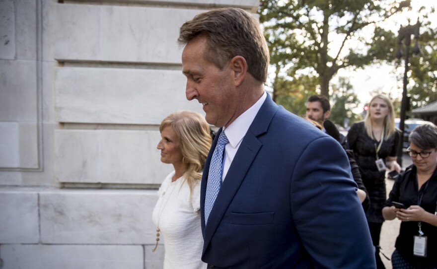 Sen. Jeff Flake, R-Ariz., accompanied by his wife Cheryl, leaves the Capitol in Washington on Tuesday after announcing he won't seek re-election in 2018.