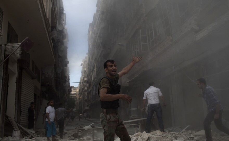 Syrian men gather amid the rubble of the Nur al-Shuhada mosque, which was shelled by forces loyal to Syrian President Bashar Assad, on Oct. 17, 2012, in the Shaar district of Aleppo.