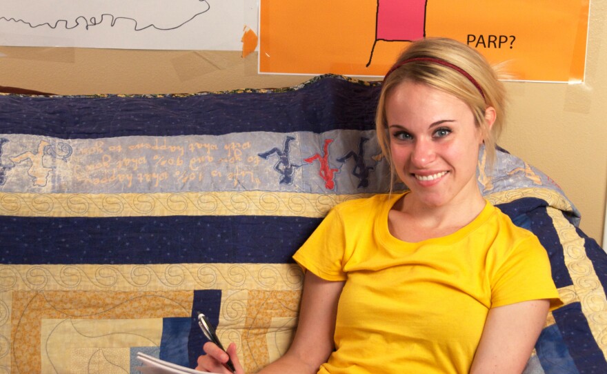 <em></em> <em>Hyperbole and a Half</em> is Allie Brosh's first book. In it, as on her blog, she draws herself with a tube body and a yellow, triangle ponytail.