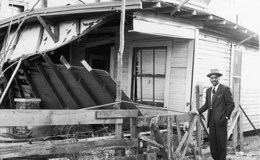 <p>In this undated photo, Shuttlesworth stands near his Birmingham home after it was bombed. </p>