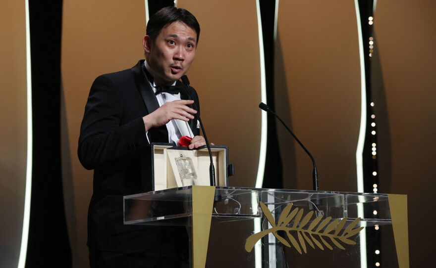 Japanese director Ryusuke Hamaguchi delivers a speech after receiving the best screenplay award for <em>Drive My Car</em> at the 2021 Cannes Film Festival in France.