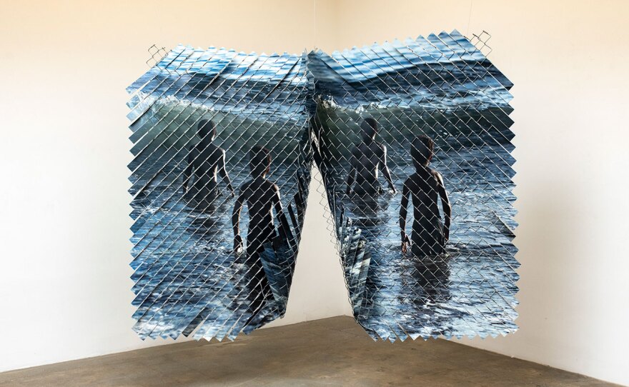 Work by Glen Wilson combines photography and chainlink fence, shown in an undated photo.