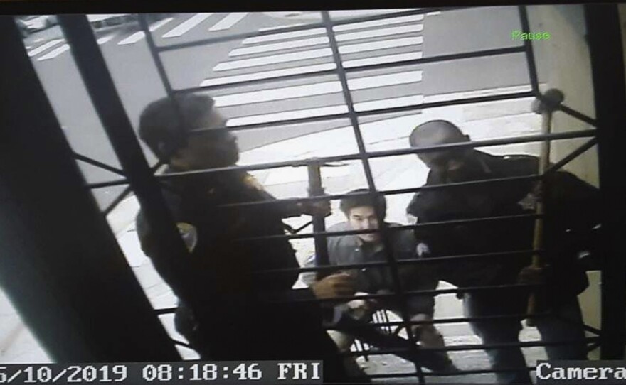 An image from surveillance camera video shows the encounter with police at the home of journalist Bryan Carmody in May. A judge this week quashed a search warrant used by the San Francisco Police Department.