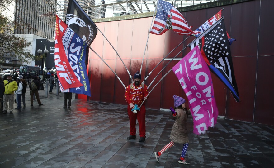 An attendee displays flags during the rally held by the Washington Three Percent in Seattle last month.