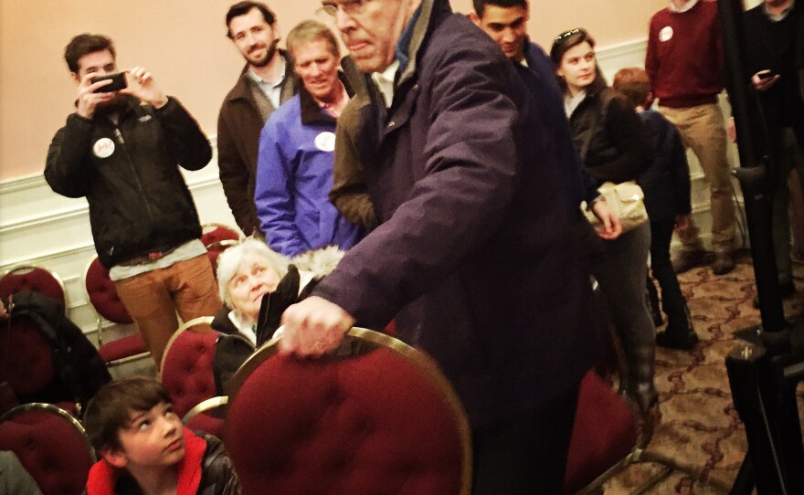 Bush helps put out additional chairs at his final New Hampshire town hall in Portsmouth on Monday evening.