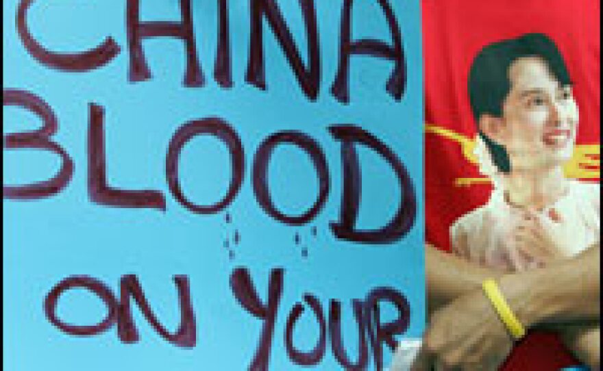 Myanmar activists display an anti-Chinese slogan and portrait of detained democracy leader, Aung San Suu Kyi during a demonstration in front of Myanmar embassy in Bangkok on Sunday.