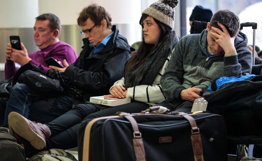 Passengers wait Friday at London's Gatwick Airport, where drone sightings repeatedly caused flights to be delayed and suspended at the height of holiday travel season.
