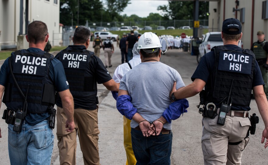 Special agents with Homeland Security Investigations, the investigative arm of U.S. Immigration and Customs Enforcement, lead a man away from Fresh Mark in Salem, Ohio, on Tuesday. The mass arrests were the result of the second such large-scale raid this month.