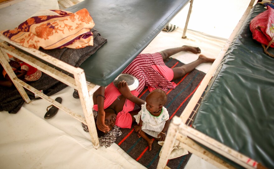 The floor is the coolest place to be in the heat of the day. A mom and her daughter rest in one of the children's wards.