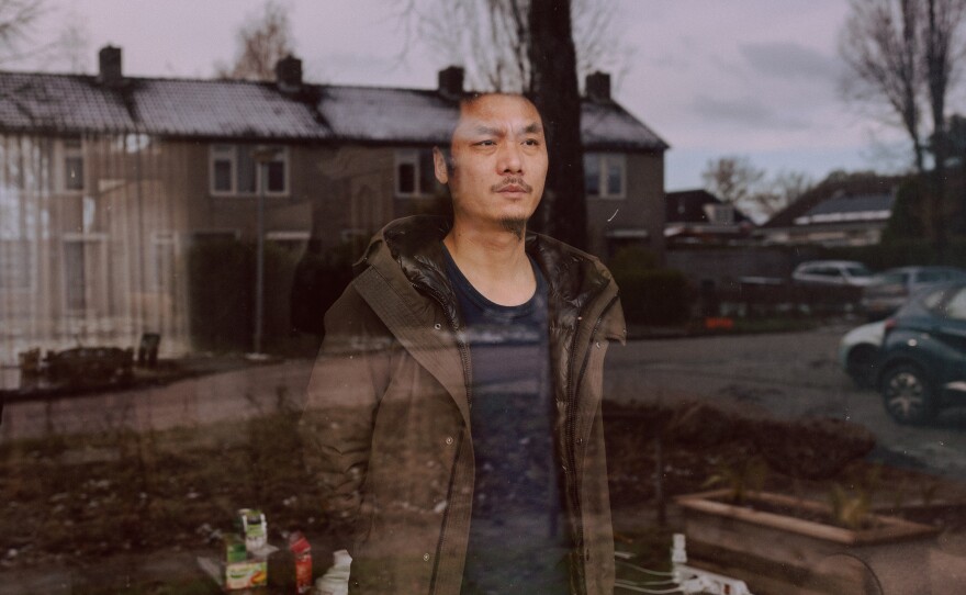 With his family stuck in Thailand, Chinese dissident Gao Zhi looks out the window of his home in a small village in the Netherlands.