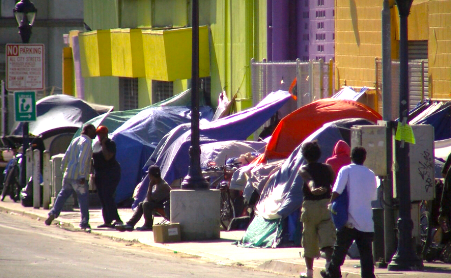 People stand outside of tents on 17th Street in San Diego's East Village, Nov. 25, 2016.