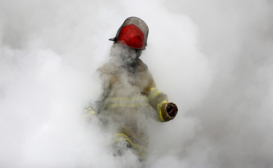 An Afghan firefighter emerges from the smoke from a fire in a Kabul clothing market in 2012. The fire department is remarkably professional in a city where few institutions function.