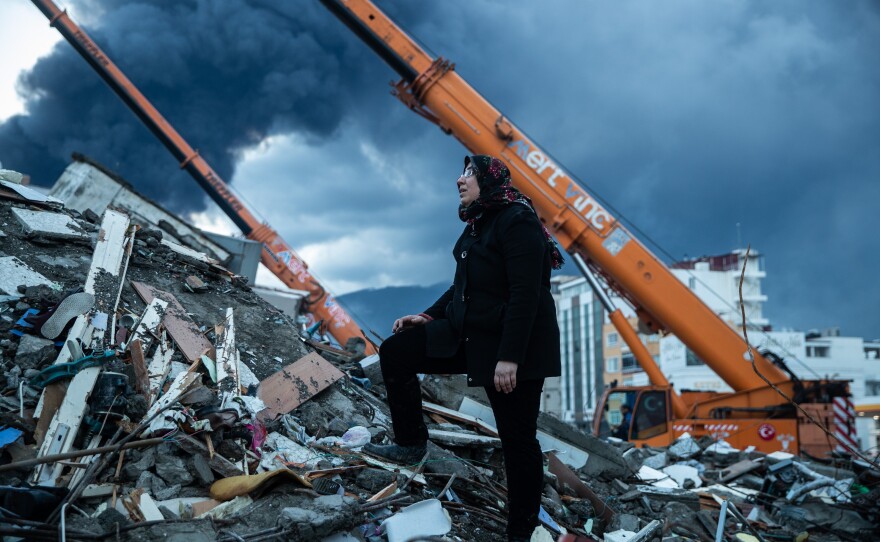 A woman waits for news of her loved ones who are believed to be trapped under collapsed building in Iskenderun, Turkey on Tuesday.