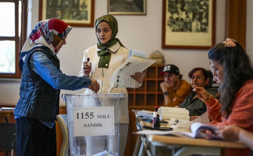 A woman votes at a polling station in Istanbul, Turkey, Sunday, March 31, 2024.