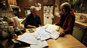 Dennie and Kathy Wright sift through a stack of medical bills at their home in Indian Valley, Calif.