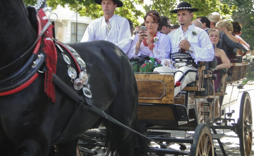 Dressed in traditional Polish Highlander garb, guests pile into carriages that will bring them to the church for the official wedding ceremony.