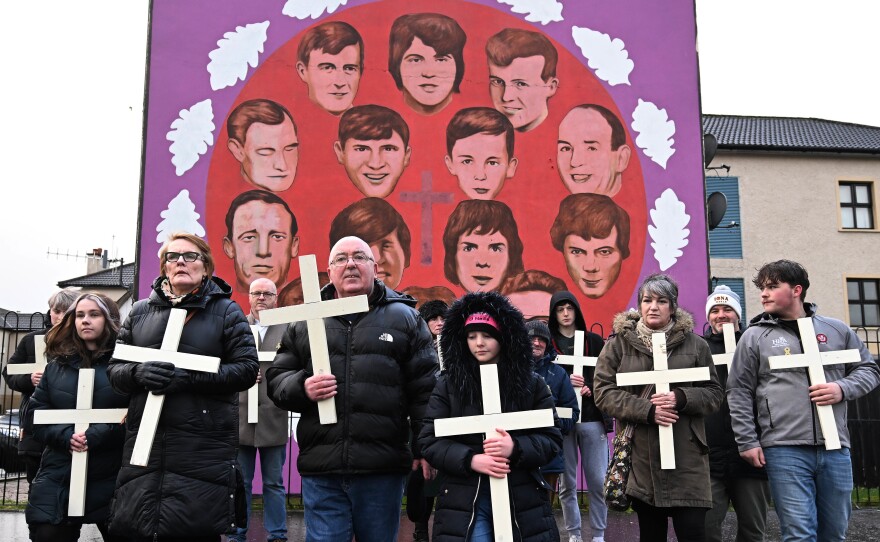 Families of the victims and supporters walk past a mural featuring the 14 victims holding crosses as they mark the 50th anniversary of Bloody Sunday on Sunday in Londonderry, also known as Derry, Northern Ireland.