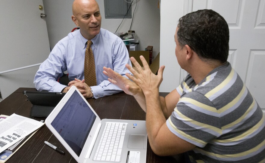 Tim Canova, left, talks with his chief of staff, Richard Bell at his campaign headquarters in Hollywood, Fla.