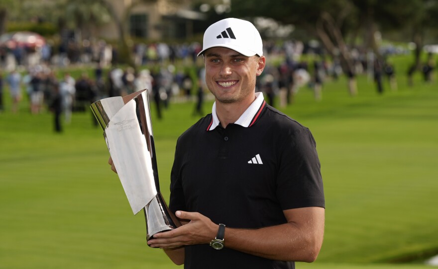 Ludvig Åberg, of Sweden, poses with the trophy after winning the Genesis Invitational golf tournament Sunday, Feb. 16, 2025, in San Diego.