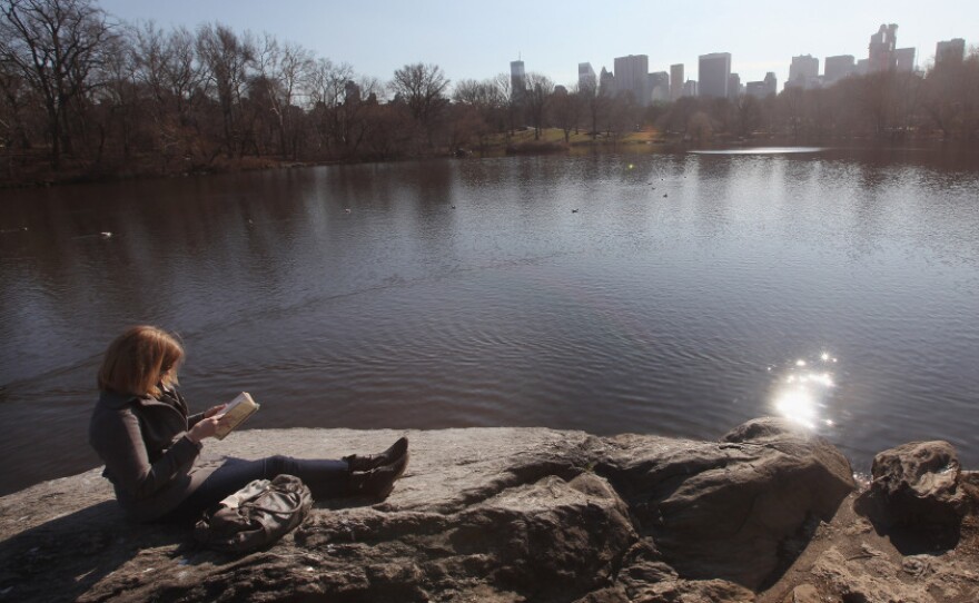 A woman takes in the sunshine while reading in Central Park on Feb. 1 in New York City, where temperatures topped 60 degrees.