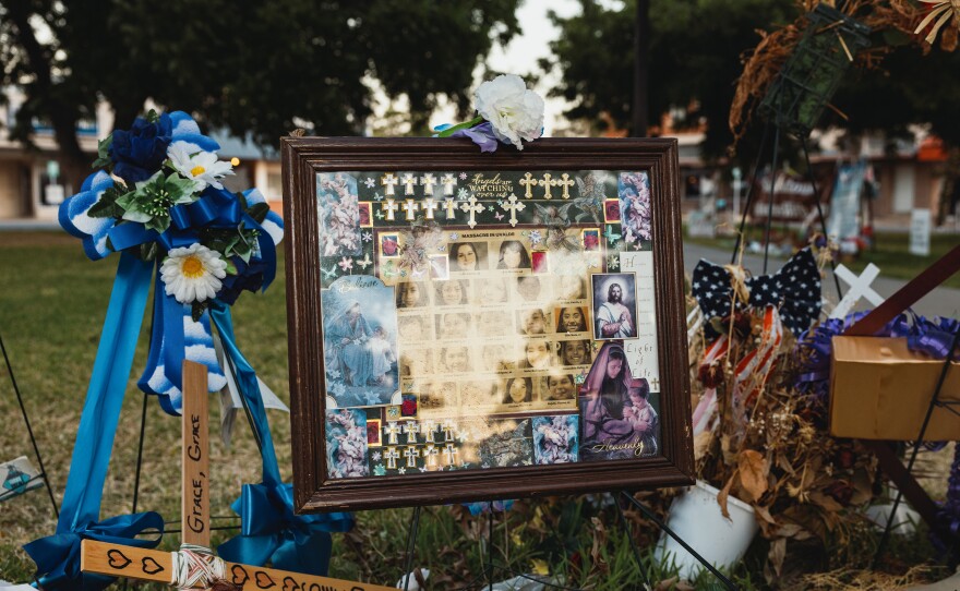 A framed picture is adorned with flowers and crosses at a memorial for the victims of the mass shooting at Robb Elementary School on June 25.