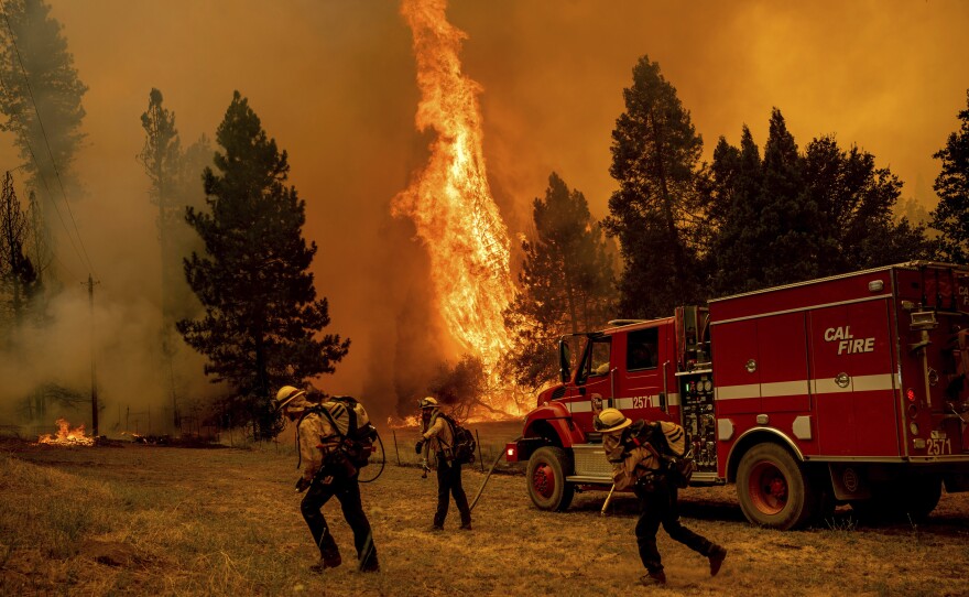 Firefighters work to keep the Oak Fire from reaching a home in the Jerseydale community of Mariposa County, Calif., on Saturday.
