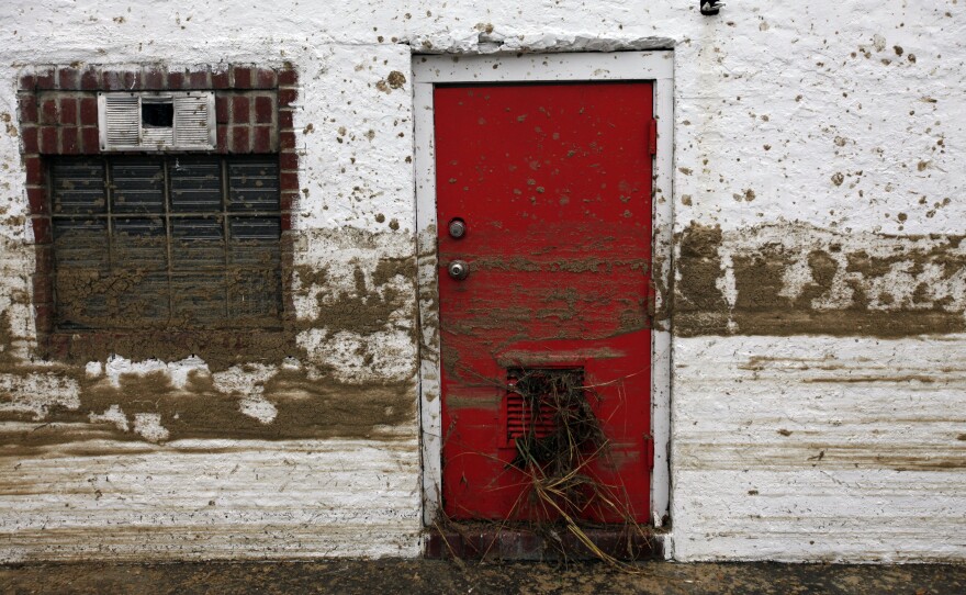 Sand marks the floodwater line on the side of a house in Long Beach, N.Y.