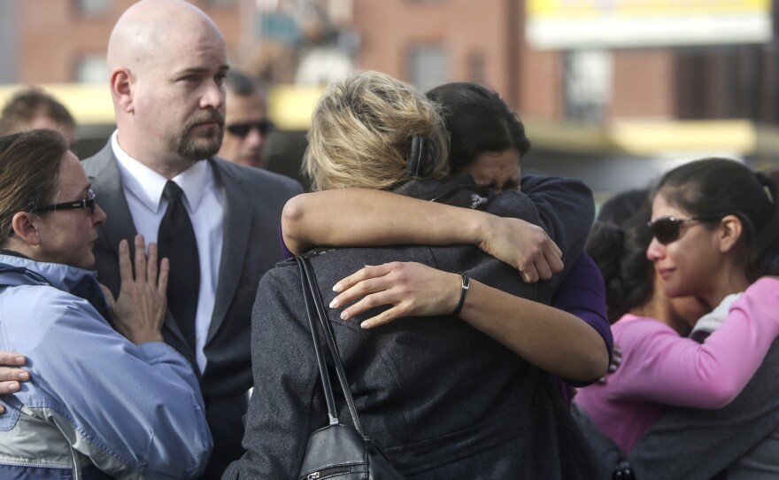 Church members mourn the murder of Father Eric Freed outside of St. Bernard Church in Eureka, Calif., on Wednesday.